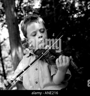 Kleiner Junge spielt Violine außerhalb Stockfoto