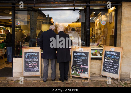 Paar durchsuchen Fenster einer Metzgerei s in Burford in Cotswolds Vereinigtes Königreich Stockfoto