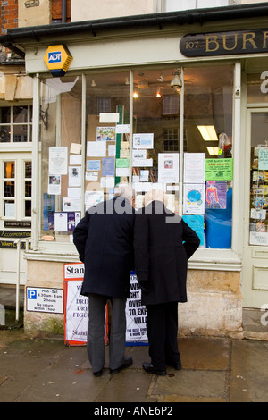 Paar durchsuchen Fenster einen Zeitungsladen s Shop bei Burford in Cotswolds Vereinigtes Königreich Stockfoto