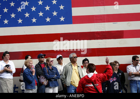 Ein Enthnically Diverse Reisegruppe vor einer großen amerikanischen Flagge, San Francisco, Kalifornien Stockfoto