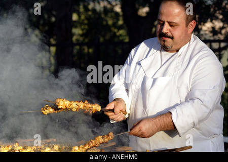 Koch stellt sich Spieße mit Hähnchen auf dem Grill Stockfoto