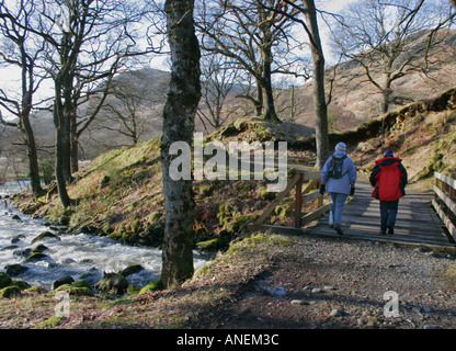 Zwei Menschen wandern im Winter in Glen Trool im Galloway Forest Park, Dumfries und Galloway, Süd-West-Schottland. Stockfoto