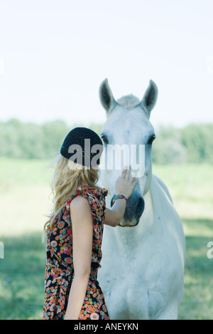 Junge Frau Pferd zu berühren Stockfoto