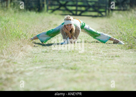 Junge Frau dabei spaltet im ländlichen Bereich, lächelnd in die Kamera Stockfoto