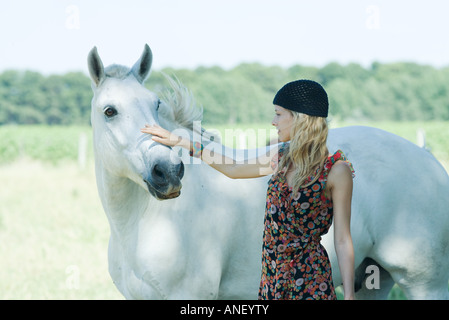 Junge Frau Petting Pferd Stockfoto