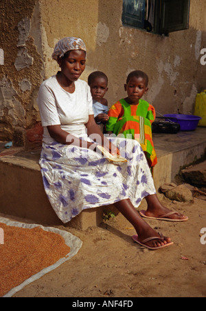 Mutter & Kinder in bunten Trachten draußen Schlamm Hütte Acholy Elendsviertel Kampala-Uganda-Ost-Afrika Stockfoto