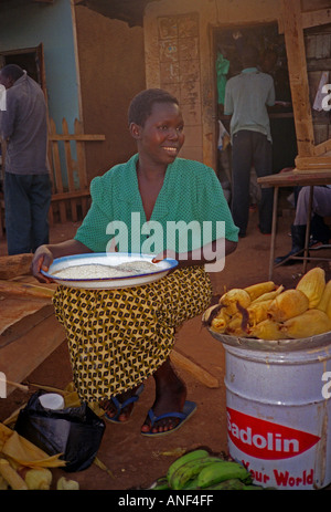 Junge schwarze afrikanische lächelnde Frauen, Pfannkuchen und Kuchen in einem Straßenmarkt Entebbe Uganda Ostafrika Stockfoto