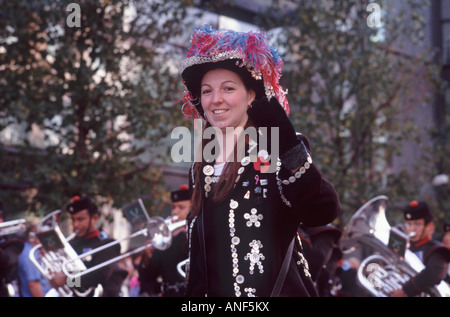 Lächelnde junge Pearly Queen in traditionellen glänzend Knopf-Sakko und Feder Hut, Lord Mayor es Show, City of London getrimmt Stockfoto