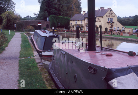 Zwei Dampf angetrieben Narrowboats neben Leinpfad mit Blick auf das blaue Lias Pub am Stockton Bottom Lock, Warwickshire, England Stockfoto