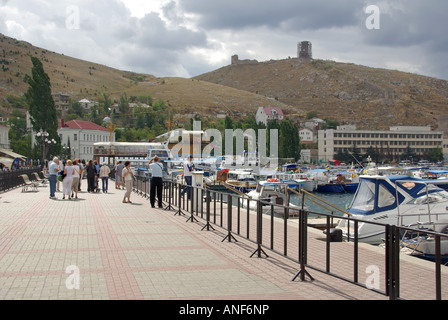 Balaclava Bay harbour, Touristen und eine Zeit sowjetischen nuklearen u-Boot-Basis Boote neben Promenade Hang Genueser Festung jenseits Stockfoto