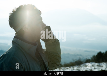 Junger Mann gekleidet in Winterkleidung, mit Handy Stockfoto