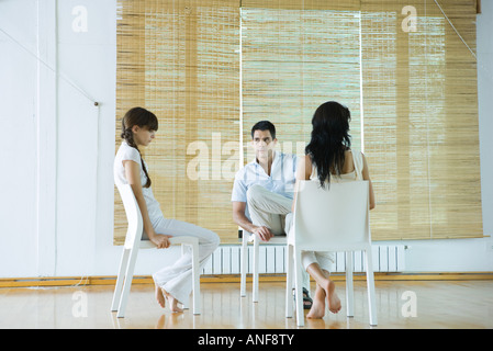 Drei Erwachsene sitzen auf Stühlen, dass Therapie-Session, ernst Stockfoto