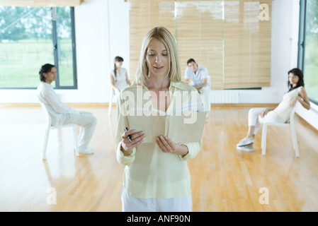 Frau führenden Gruppentherapie-Sitzung, liest aus Buch, gerichtete Kamera Stockfoto