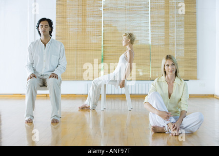 Drei Erwachsene in verschiedenen Haltungen im Wellness-center Stockfoto