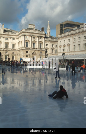 Erwachsene & Kinder Eisläufer mit Hintergrund historischen Somerset House Gebäude & Innenhof auf temporäre Winter Eislaufbahn Strand London, England, Großbritannien Stockfoto