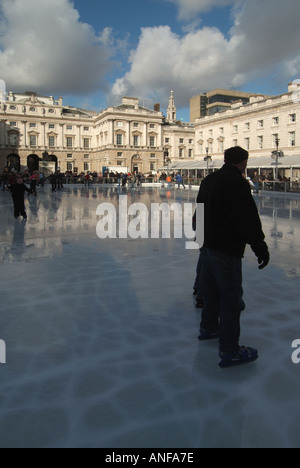 Erwachsene & Kinder Eisläufer mit Hintergrund historischen Somerset House Gebäude & Innenhof auf temporäre Winter Eislaufbahn Strand London, England, Großbritannien Stockfoto