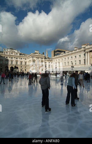 Erwachsene & Kinder Eisläufer mit Hintergrund historischen Somerset House Gebäude & Innenhof auf temporäre Winter Eislaufbahn Strand London, England, Großbritannien Stockfoto