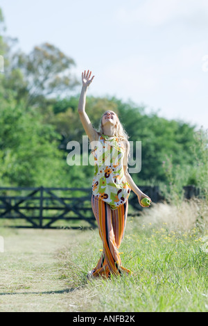 Junge Frau im ländlichen Bereich mit Arm hob, nachschlagen, Apfel in der hand Stockfoto