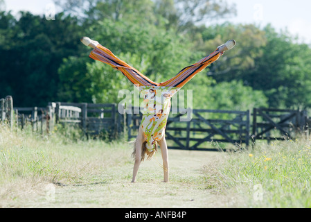 Junge Frau tun Handstand im ländlichen Bereich Stockfoto