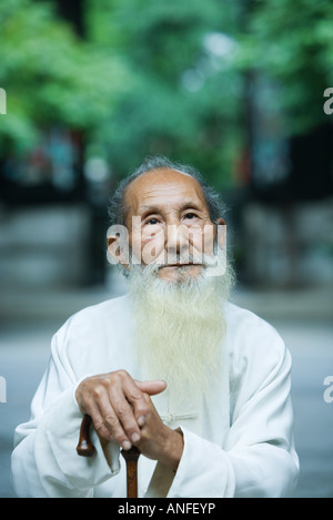 Ältere Menschen tragen traditionelle chinesische Kleidung, halten Zuckerrohr Stockfoto