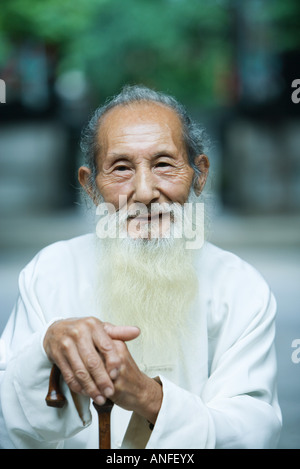 Ältere Menschen tragen traditionelle chinesische Kleidung, halten Zuckerrohr Stockfoto