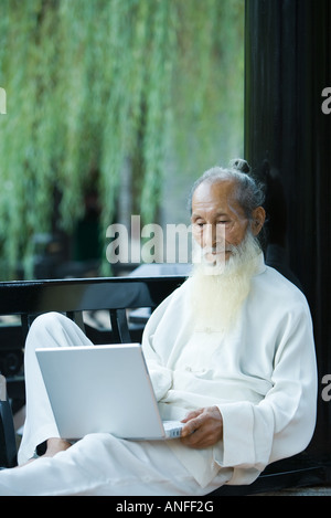 Ältere Menschen tragen traditionelle chinesische Kleidung, mit laptop Stockfoto