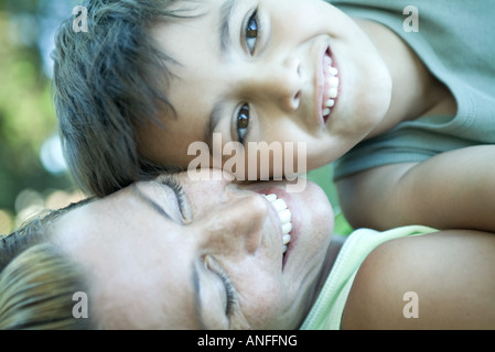 Junge und Mutter liegend, Wange an Wange Stockfoto
