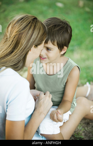 Mutter und Sohn sitzen im Freien, spielen zusammen Stockfoto