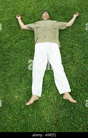Mann liegt auf dem Rasen, in voller Länge Stockfoto