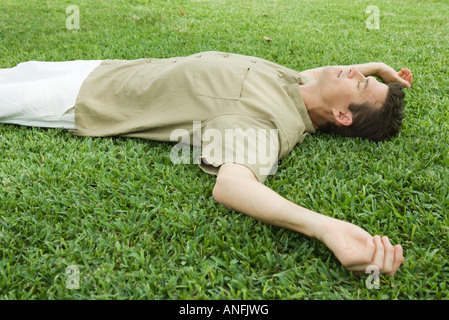 Mann liegt auf dem Rasen Stockfoto