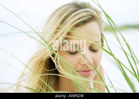 Frau, schließen der Augen, gesehen durch Rasen, Nahaufnahme Stockfoto