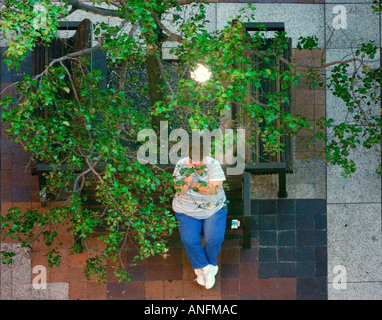 Frau sitzt auf einer Parkbank Stockfoto
