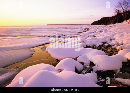 Die Sonne geht über der verschneiten Georgian Bay Küste im Winter, Färber Bay, Bruce Peninsula, Ontario, Kanada. Stockfoto