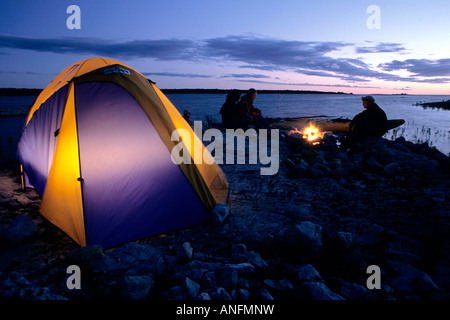 Camper genießen Sie ein Feuer am Ufer des Lake Huron bei Sonnenuntergang, in der Nähe der Stadt Tobermory, Bruce Peninsula, Ontario, Kanada. Stockfoto