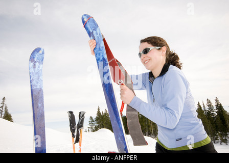 Eine Frau legt ihre Klettern Skins auf ihre Backcountry-Ski in Vorbereitung zum Aufstieg auf den Hügel für einen anderen Lauf. Strathcona Stockfoto