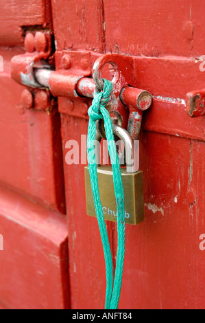 Vorhängeschloss und Hasp und Grundnahrungsmittel, rot gemalte Hütte Tür zu sichern Stockfoto