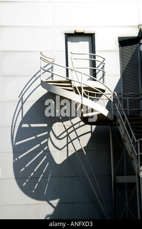 Feuerleiter und Wendeltreppe in kontrastreichen Sonnenlicht und Schatten Stockfoto