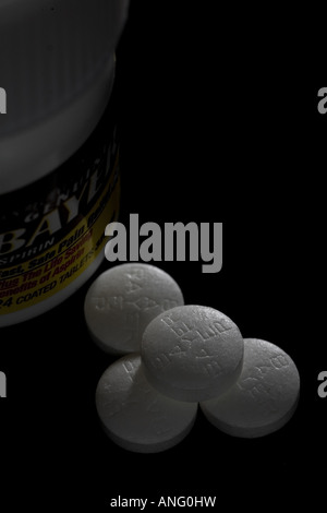 4 Aspirin-Tabletten und Flasche auf schwarzem Hintergrund Stockfoto