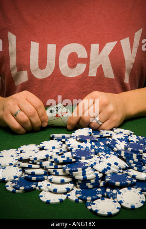 Mann, hält gewinnende Pokerhand mit Haufen Chips, mit einem glücklichen t-shirt Stockfoto