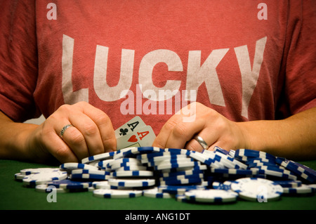 Mann, hält gewinnende Pokerhand mit Haufen Chips, mit einem glücklichen t-shirt Stockfoto