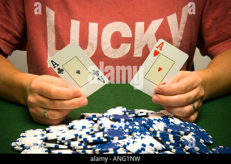 Mann, hält gewinnende Pokerhand mit Haufen Chips, mit einem glücklichen t-shirt Stockfoto