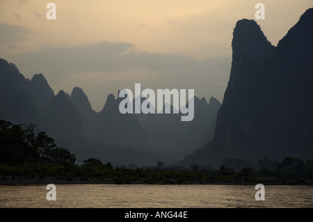 Blick über den Fluss Li Jiang auf die Kalkstein-Berggipfel zwischen Xinping und Yangshuo, Guangxi, China. Stockfoto