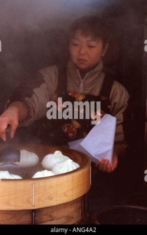 Ein junges Mädchen verkaufen dampfende Schweinefleisch Brötchen in Sapporo, Hokkaido, Japan Stockfoto