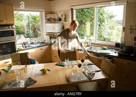 Junge Frau die Küche aufräumen St Mawes Cornwall Stockfoto