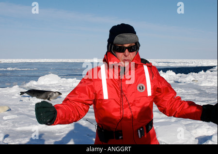 Mann trägt rote Jacke mit Eisschollen im Hintergrund Stockfoto