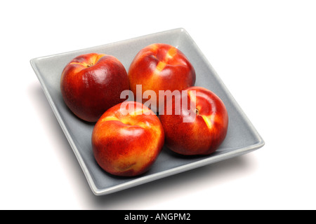 Nektarinen in Keramikschale auf weiße Fläche Stockfoto