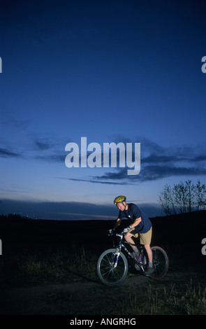 Mountainbiker in der Abenddämmerung in Nase Hill Park, Calgary, Alberta, Kanada Stockfoto