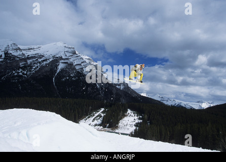 Junge männliche Snowboarder springen im Terrainpark am Mt Norquay, Banff Nationalpark, Alberta, Kanada Stockfoto