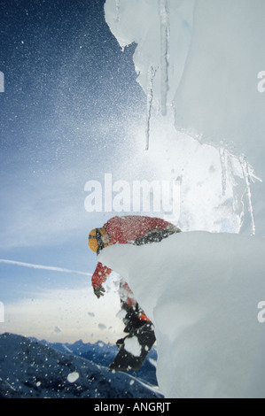 Junge männliche Snowboarder springen von einem Gesims am Sunshine Village, Banff Nationalpark, Alberta, Kanada Stockfoto