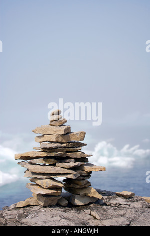 Rock Inukshuk auf einem Felsvorsprung Backdropped von Packeis verschleiert durch Nebel in der Strait Of Belle Isle, Labrador Coastal Drive, Viking Trail Stockfoto